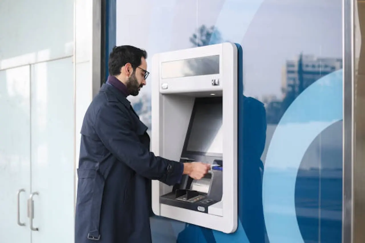 man using atm machine at an atm business