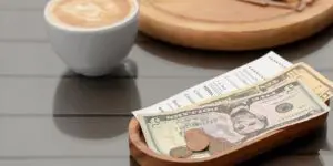 cash tips with receipt cup of coffee and pastry