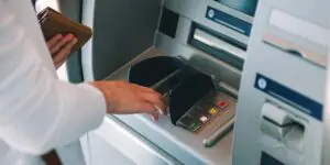 woman pressing key pin code at an atm machine