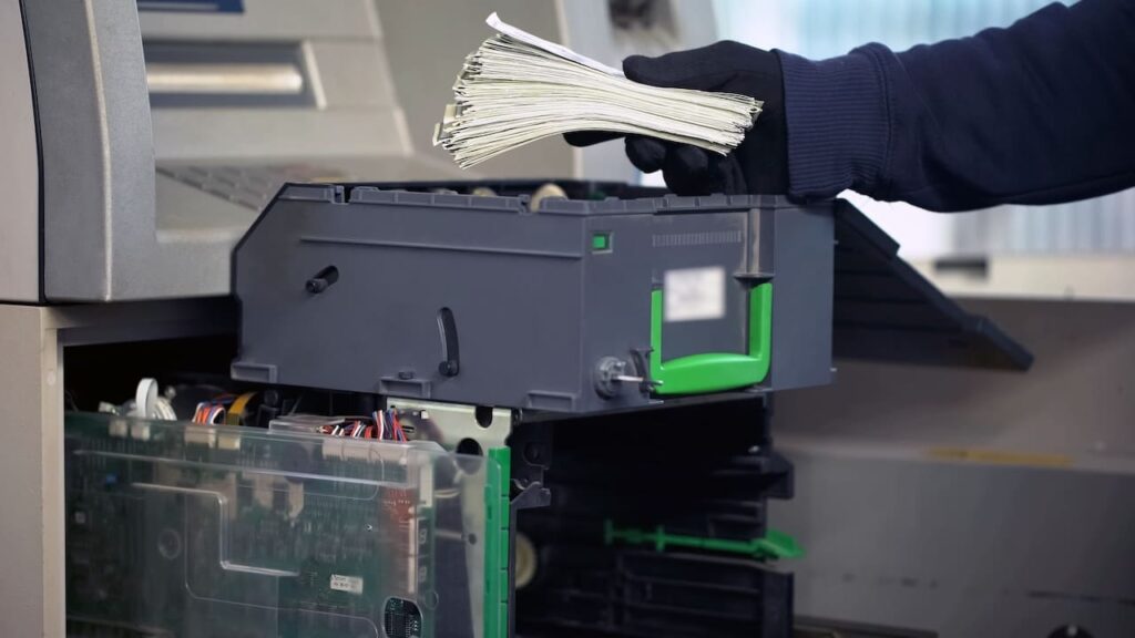 bank employee loading cash in ATM machine