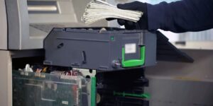 bank employee loading cash in ATM machine