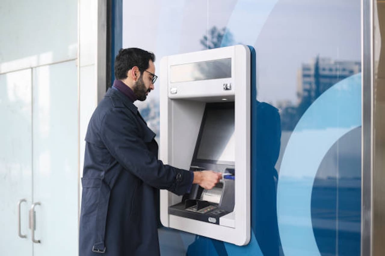 man using atm machine at an atm business